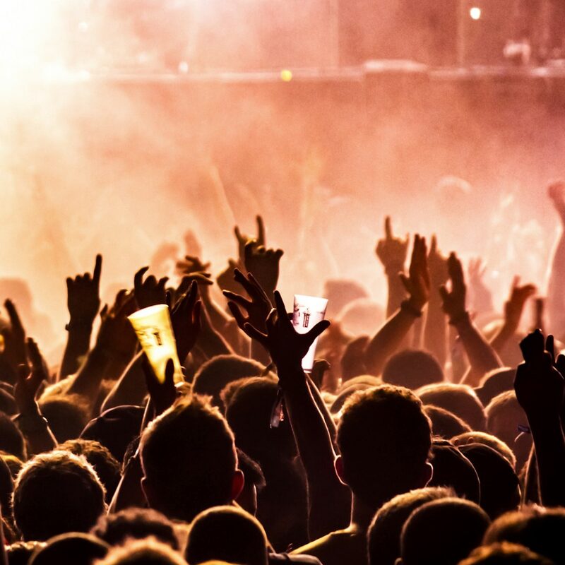 Nightclub crowd with hands up under stage lights in Dubai